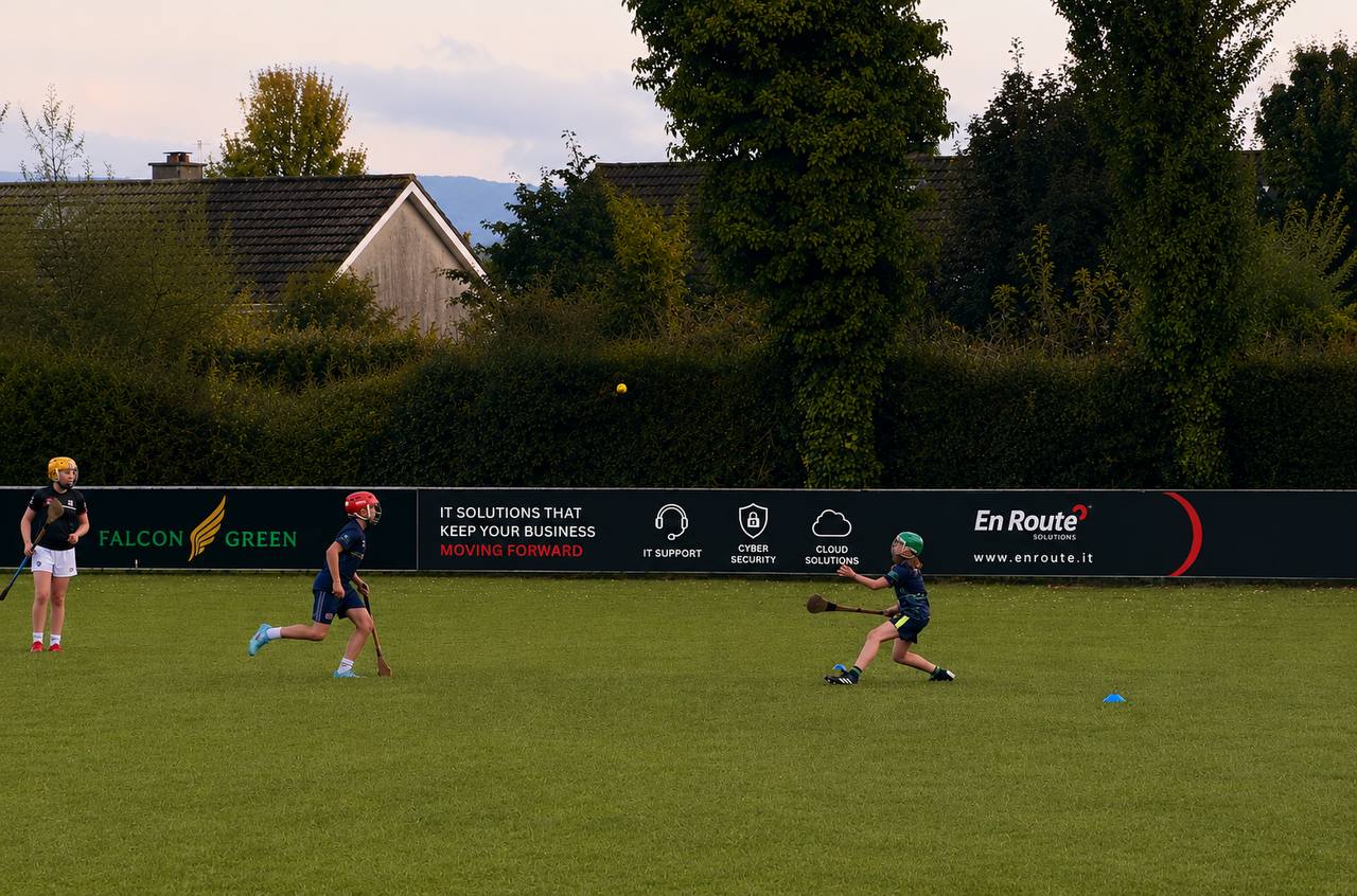 Young players training in front of the En Route Solutions pitchside advertising board