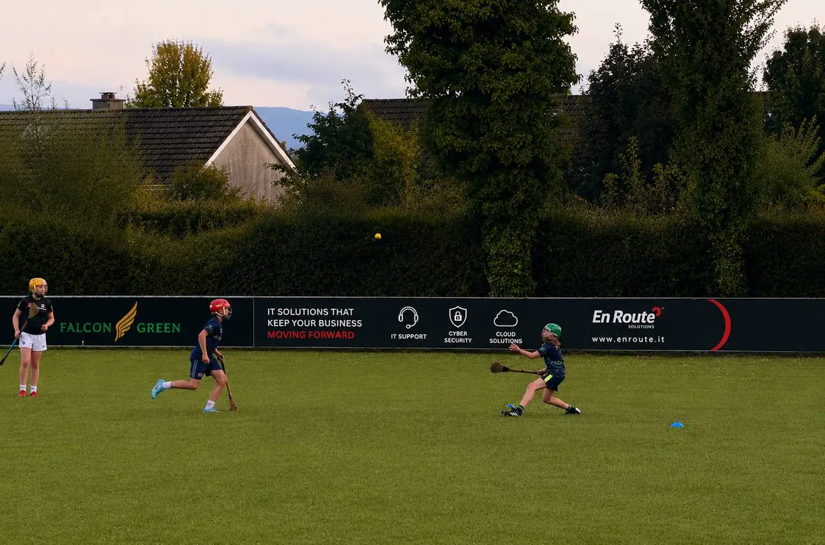 Young players training in front of the En Route Solutions pitchside advertising board