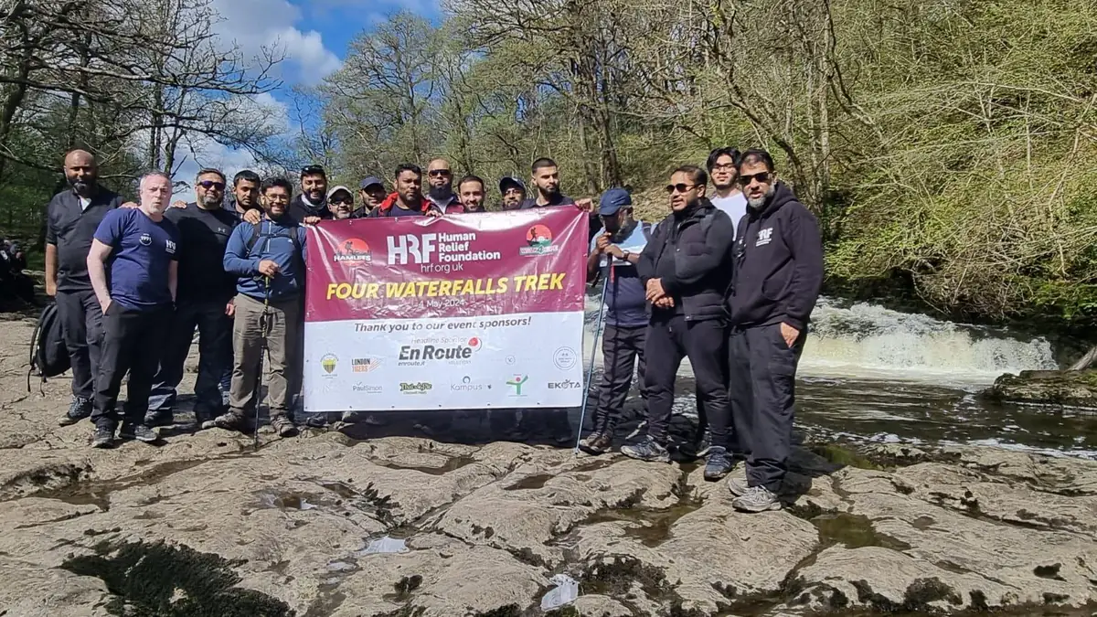 Four Waterfalls Trek group with the Human Relief Foundation banner, headline sponsored by En Route Solutions