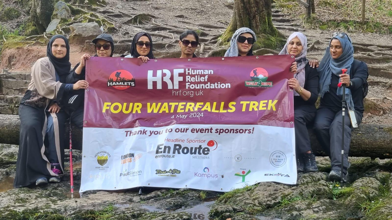 Four Waterfalls Trek women's group holding the Human Relief Foundation sponsorship banner